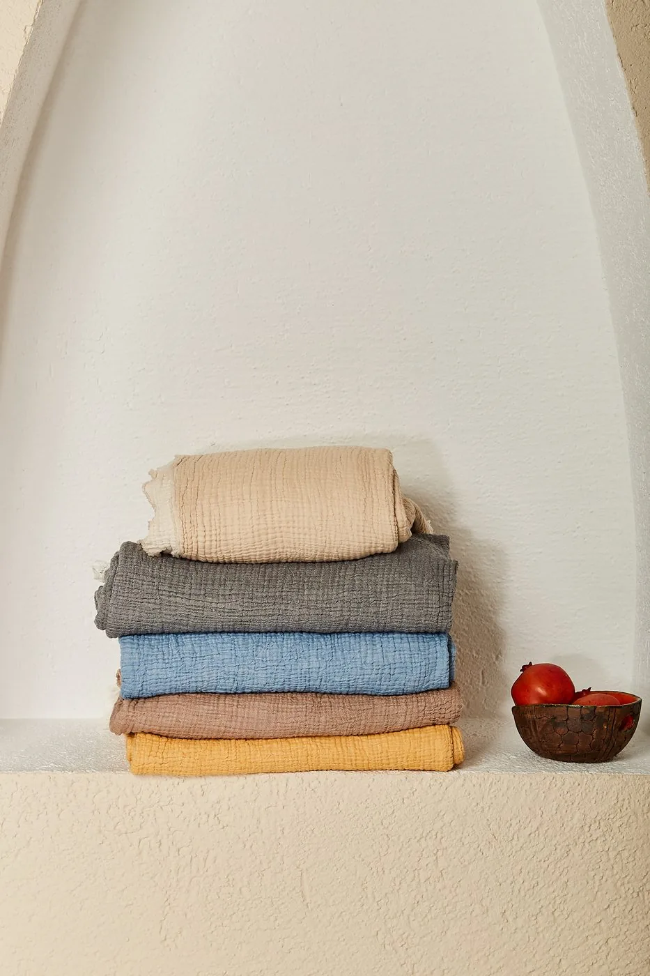 Folded gauze muslin blankets in beige, grey, blue and mustard