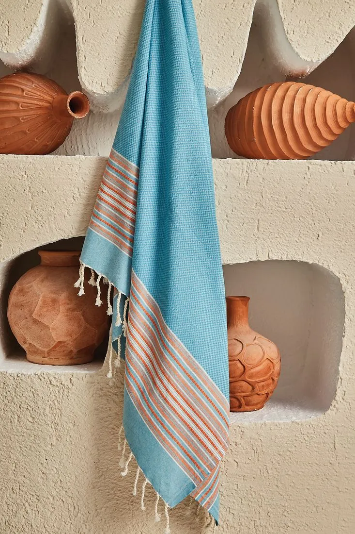 Afrodit cotton peshtemal in turquoise with orange stripes, hanging in a plaster niche