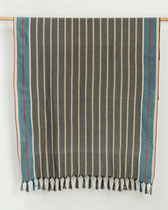 Cunda striped cotton beach towel hanging on a wooden rail