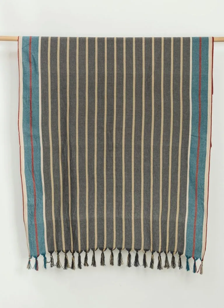 Cunda striped cotton beach towel hanging on a wooden rail